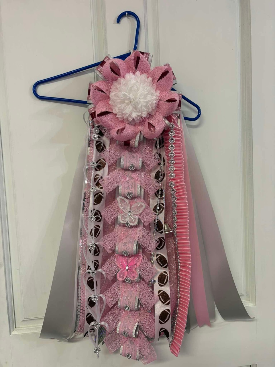 Pink football-themed ribbon arrangement with butterfly details