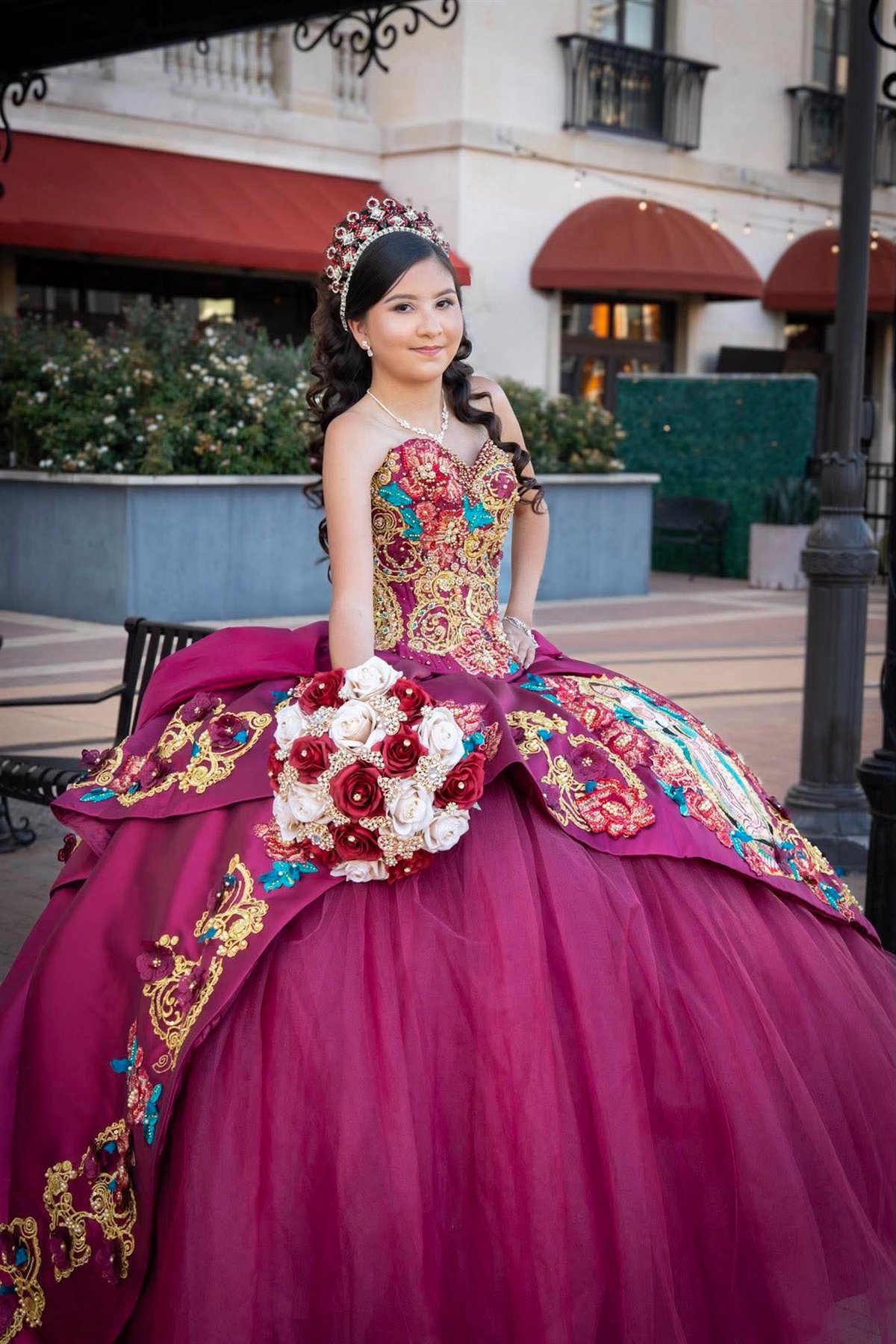 Quinceañera in a pink gown holding a bouquet