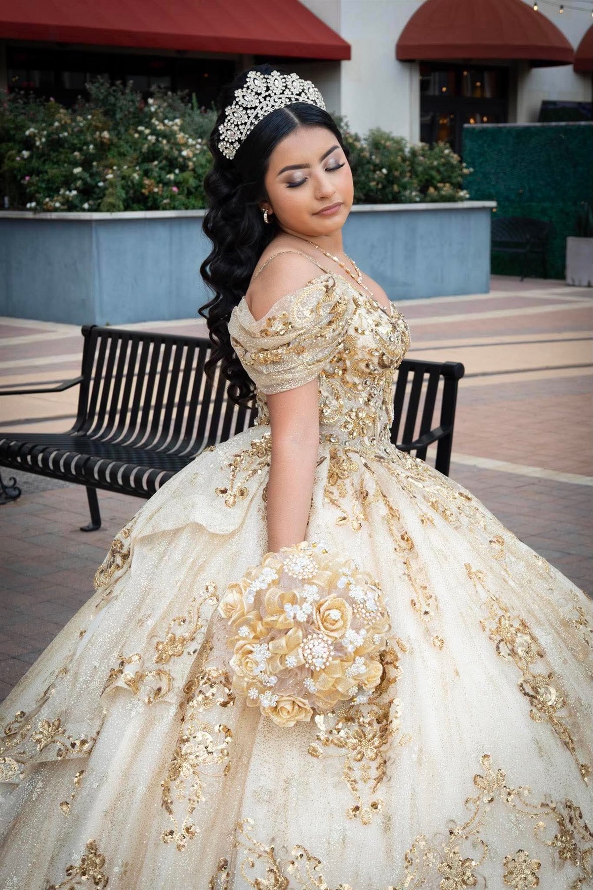 Quinceañera in a gold gown with bouquet