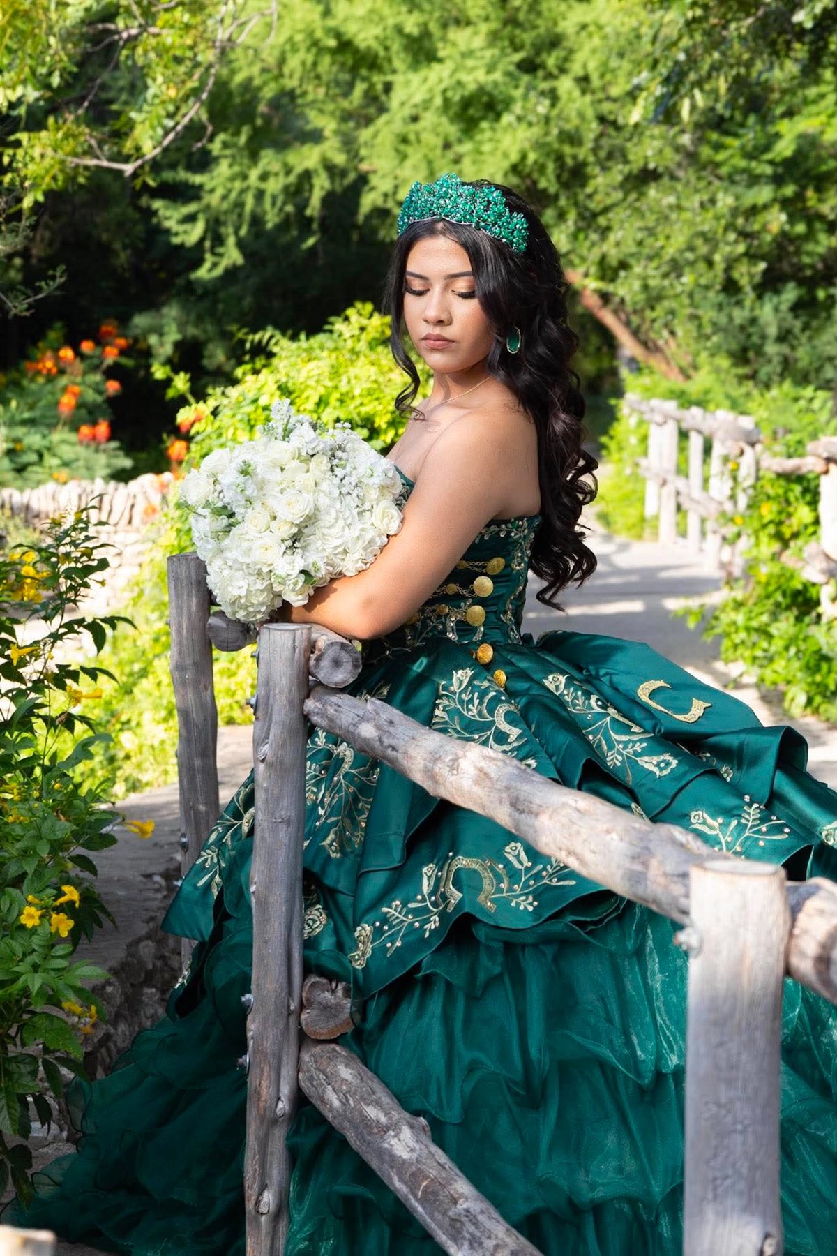 Quinceañera in a green gown with bouquet