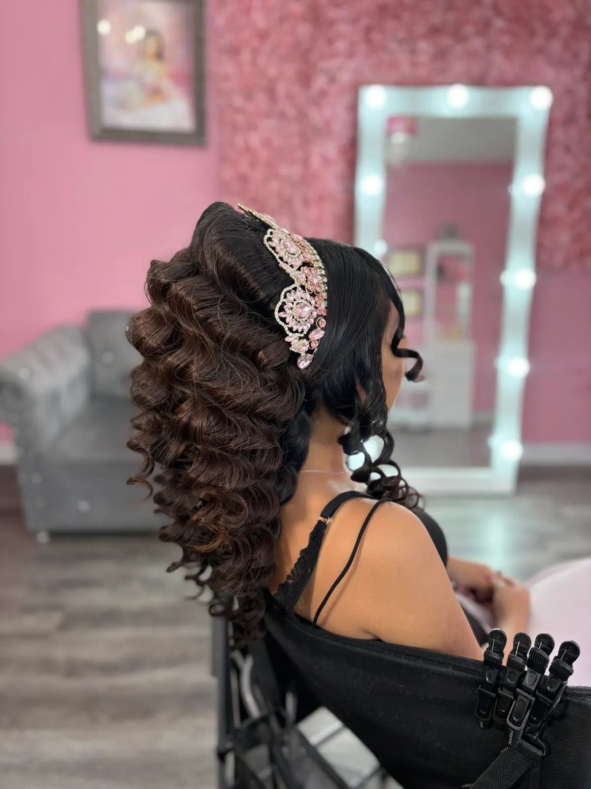 Side view of a curled quinceañera hairstyle with tiara