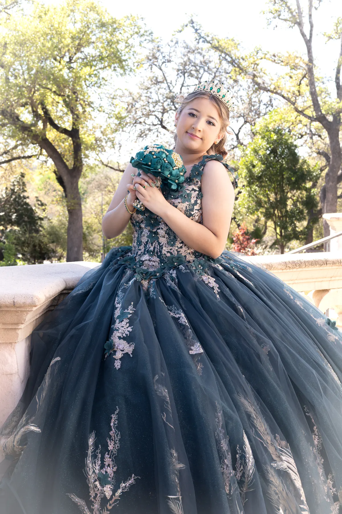 Quinceañera in a dark embroidered gown with a bouquet