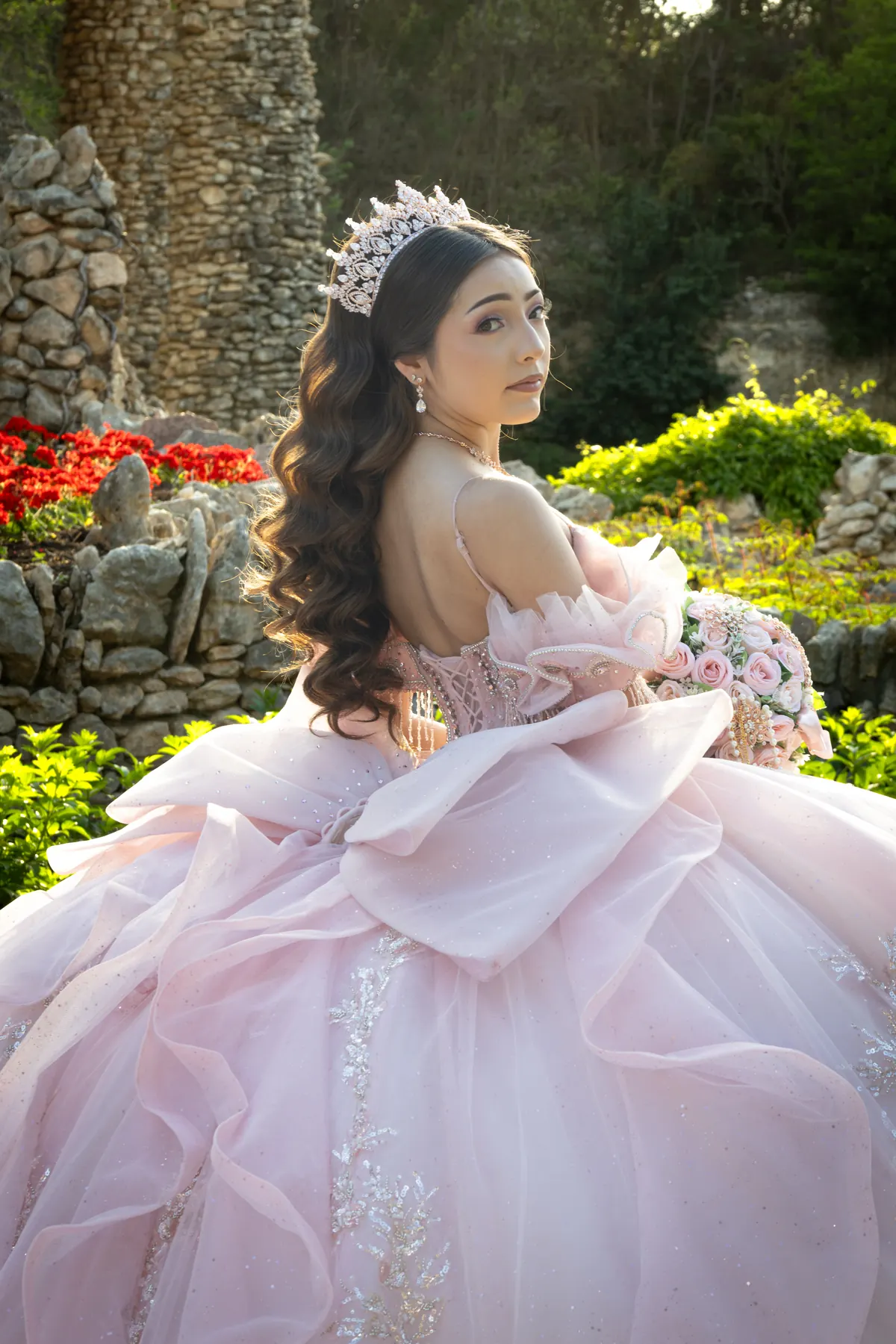 Quinceañera in a blush gown holding a bouquet